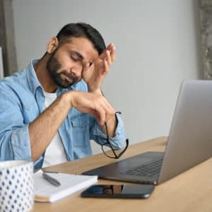 depressed-young-man-sitting-on-desk-while-working
