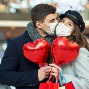 kissing couple holding heart balloons